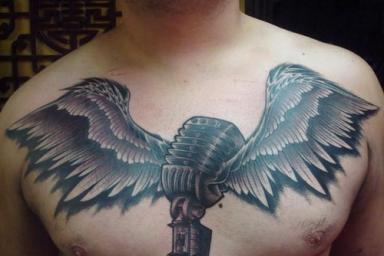 MicWithWingsTattooOnManChest.jpeg